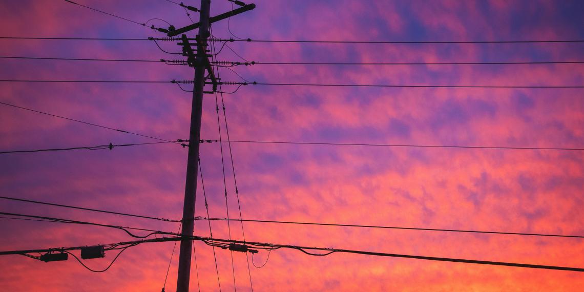 Powerlines against a colourful sunset sky